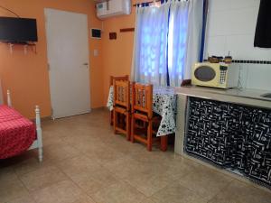 cocina con microondas, mesa y sillas en MONOAMBIENTE para 2 personas, no incluye blanqueria en Chascomús