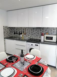 een keuken met witte kasten en een tafel met wijnglazen bij Apartaments Vacations Playa del Ingles in Playa del Inglés