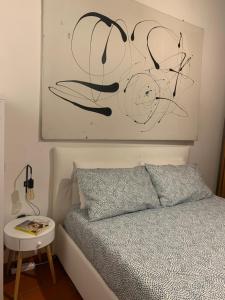 1 dormitorio con 1 cama y una foto en la pared en La casa del Centro, en Módena