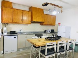 - une cuisine avec une table en bois et des appareils électroménagers blancs dans l'établissement Casa da Aldeia, à Tomar