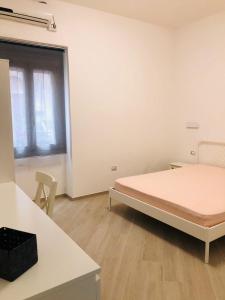 a white room with a bed and a window at Casa Novesia in Carloforte