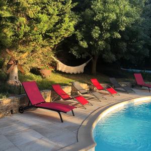 a row of lawn chairs next to a swimming pool at Fanjeaux Aude Le Chalet in Fanjeaux