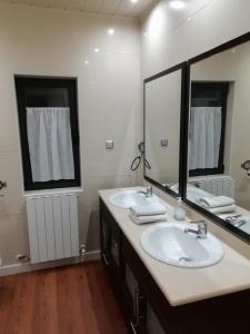 a bathroom with two sinks and a large mirror at VillaTerreno Casa Rural en Logroño in Villamediana de Iregua