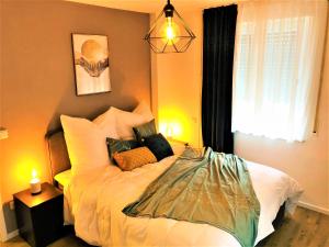 a bedroom with a bed with pillows and a window at Central-Modern, The Sunshine by SA-Grandeur in Friedrichshafen