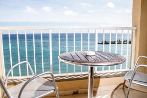 a table on a balcony with a view of the ocean at Checkin Diamar in Arrecife