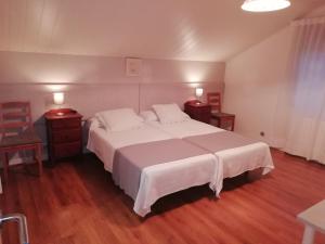 ein Schlafzimmer mit einem großen weißen Bett und zwei Nachttischen in der Unterkunft VillaTerreno Casa Rural en Logroño in Villamediana de Iregua