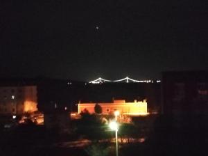 a city at night with a bridge in the background at Bahçeli Konak in Eceabat