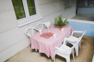 een roze tafel met witte stoelen en een plant op een patio bij Ria de Ajo in Isla