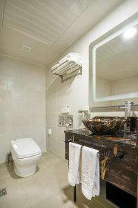 y baño con aseo, lavabo y espejo. en Embledon Hotel en Ansan