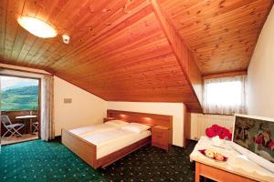 カルダーロにあるPension Hasslhofの木製の天井が特徴のベッドルーム1室(ベッド1台付)