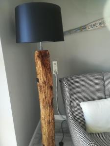 a lamp with a black lamp shade next to a chair at Klein Erna (Apth.Holländerei) in Büsum