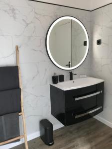 a bathroom with a sink and a mirror on a wall at Cherbourg Sea Sand in Cherbourg en Cotentin