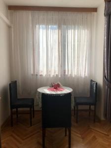 een tafel en stoelen in een kamer met een raam bij Apartment Sara in Mostar