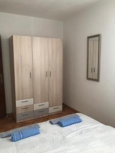 een slaapkamer met een bed en houten kasten bij Apartment Sara in Mostar