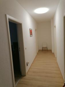 an empty hallway with a door and a chair at Kunstgasse 11, Wohnung 10 in Altenburg