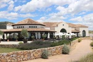 una casa grande con una pared de piedra delante de ella en LUXE Golf, Piscina & Playa, en Lo Mendigo