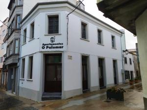 un edificio bianco con un cartello sulla parte anteriore di Paloma blanca a Villalba