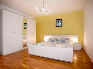 a bedroom with a white bed and a yellow wall at Apartment in Rovinj/Istrien 11491 in Štanga