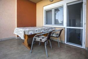 ein Tisch und zwei Stühle neben einem Fenster in der Unterkunft Apartment in Rovinj - Istrien 11491 in Rovinj + 14 Fotos
