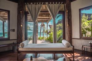 a bedroom with a large bed and a large window at Delek Tulum located at the party zone in Tulum