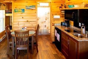 a kitchen with a table and a sink in a cabin at Crescent Beach and RV Park in Port Angeles