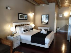 a bedroom with a large white bed and a chair at Seaport Village Holiday Accommodation in Russell