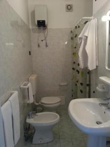 Baño blanco con aseo y lavamanos en Hotel La Collinetta, en Morciano di Leuca