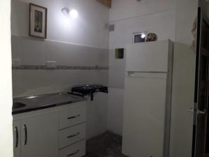 a kitchen with a white refrigerator and a sink at Hospedaje Vista al Mar in Puerto Pirámides
