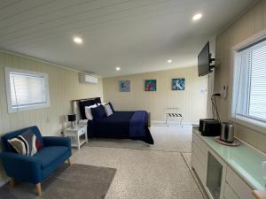 1 dormitorio con 1 cama azul y 1 silla azul en Hideaway on Hume #2, en Boonah