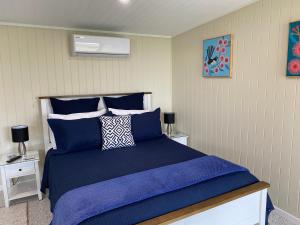 1 dormitorio con 1 cama azul y 2 mesitas de noche en Hideaway on Hume #2, en Boonah