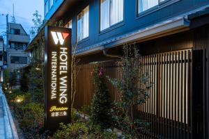 un edificio con una señal delante de él en Hotel Wing International Premium Kyoto Sanjo en Kioto