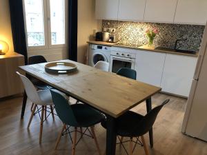 - une cuisine avec une table et des chaises en bois dans l'établissement Joli Appartement Le Gutenberg T2 4p Quartier Mirabeau Proche Gare, à Tours