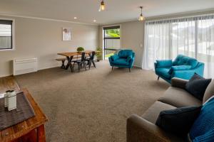 a living room with blue chairs and a table at Annies on Milford in Te Anau