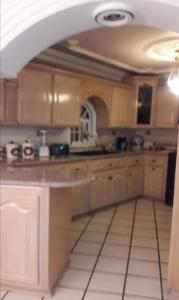 a kitchen with wooden cabinets and a white tile floor at Brenda alicia in Puerto Peñasco +6 photos