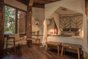 - une chambre avec un lit à baldaquin dans l'établissement Delek Tulum, à Tulum