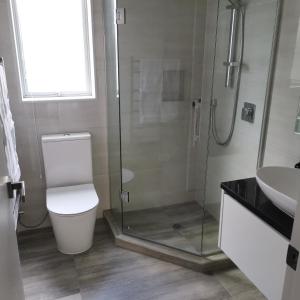 オークランドにあるCozy granny flat B&Bのシャワー、トイレ、洗面台を備えたバスルーム