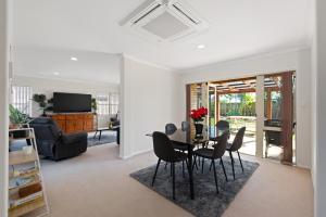 a dining room and living room with a table and chairs at Mount Holidaze - Mt Maunganui Holiday Home in Matapihi