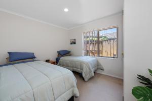 Säng eller sängar i ett rum på Mount Holidaze - Mt Maunganui Holiday Home