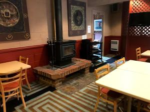 a fireplace in a restaurant with tables and chairs at Cottonwood Lodge in Berridale