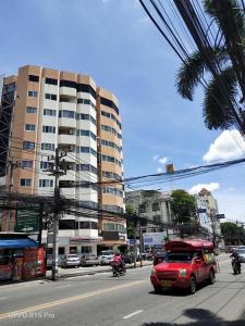 a red van driving down a city street with a building at Chill Chill at Nimman in Chiang Mai