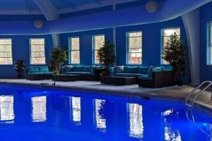 um quarto com uma piscina com paredes azuis e sofás em LovelyHouse!Escape&Nature!HiSpeedInternet! em Long Pond