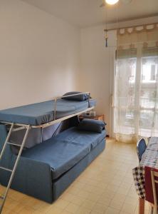 a room with a bunk bed and a couch at Mare Pineta 2 in Lido di Volano