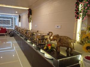 a buffet line with pots and pans and an elephant statue at Nattha By Indian Culture in Lucknow