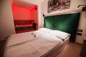 ein Schlafzimmer mit einem großen weißen Bett und einer grünen Wand in der Unterkunft Dragons Dream Hostel in Ljubljana