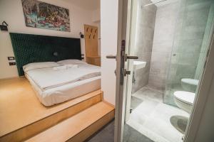 a bedroom with a bed and a bathroom with a shower at Dragons Dream Hostel in Ljubljana