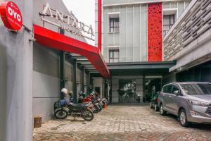 Capital O 90244 Hotel Antara في جاكرتا: صف من الدراجات النارية متوقفة أمام مبنى