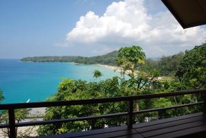 a view of a beach from a balcony at Surin Beach Ocean front Villa between Kamala and BangTao Beaches in Surin Beach