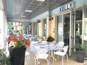 リミニにあるHotel Kellyの青いテーブルと白い椅子と花のレストランを併設しています。