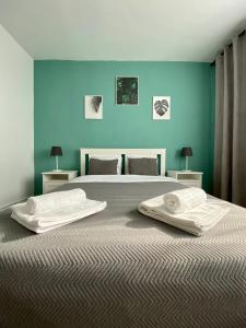 ein Schlafzimmer mit einem großen Bett mit blauen Wänden in der Unterkunft BCB Aparts Mountain View in Braşov