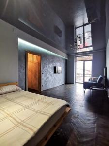 a bedroom with a large bed and a chair at Loft style apartments in the center in Sumy